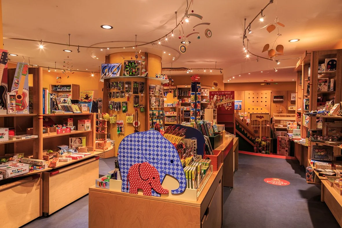 Blick in den Hampelmann-Laden mit Holzregalen und Spielzeug